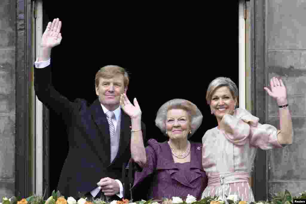 Putri Beatrix dari Belanda (tengah), putranya, Raja Belanda Willem-Alexander yang berusia 46 tahun dan istrinya Ratu Maxima melambaikan tangan kepada kerumunan warga dari balkon Istana Kerajaan di Amsterdam.