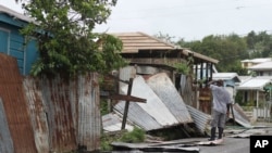 Un hombre en la isla de St. John's, en Antigua y Barbuda, revisa los restos de su propiedad luego del paso del huracán Irma. Sept. 6, 2017.
