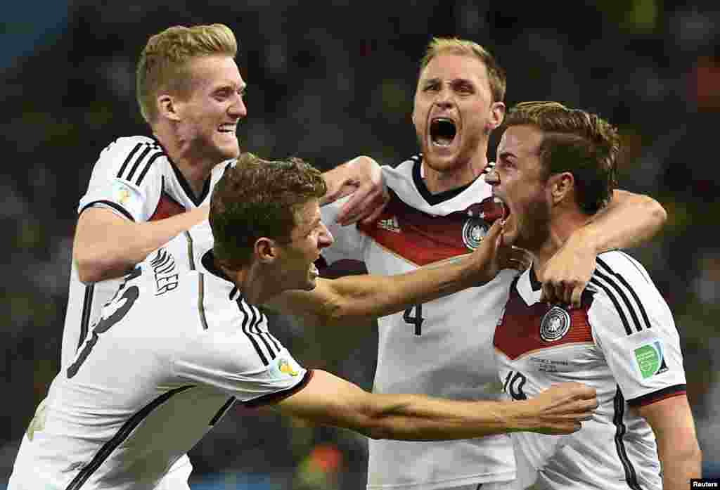 Germany's Mario Goetze celebrates his goal against Argentina with teammates (L-R) Andre Schuerrle ,Thomas Mueller and Benedikt Hoewedes during extra time in their 2014 World Cup final at Maracana stadium in Rio de Janeiro, Brazil, July 13, 2014.
