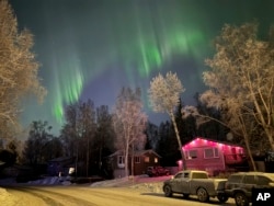 FILE - The northern lights appear over homes in Anchorage, Alaska, on Wednesday, Jan. 1, 2025. (AP Photo/Mark Thiessen)