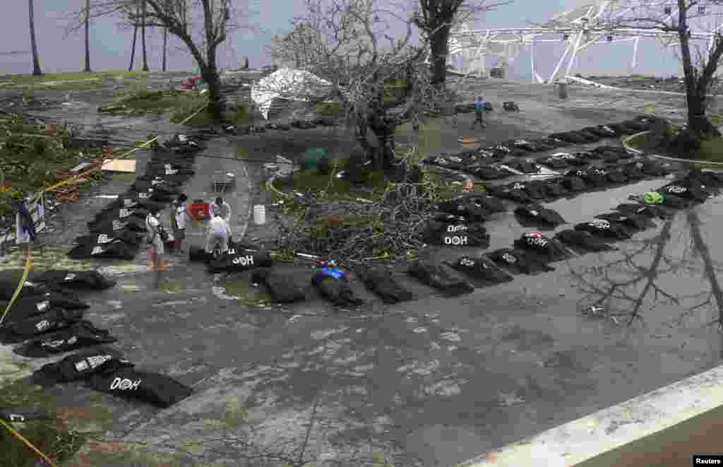 Tim penyelamat berdiri di dekat tas-tas yang berisi jenazah korban bencana topan Haiyan di kota Tacloban, Filipina tengah.
