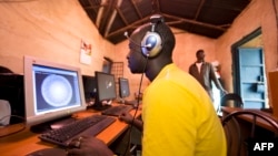 FILE - Young men surf the internet at a cybercafe on June 20, 2012, in the Kibera division of Nairobi. 