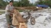 A villager is seen here tying timber to his motorcycle for trading, file photo. 
