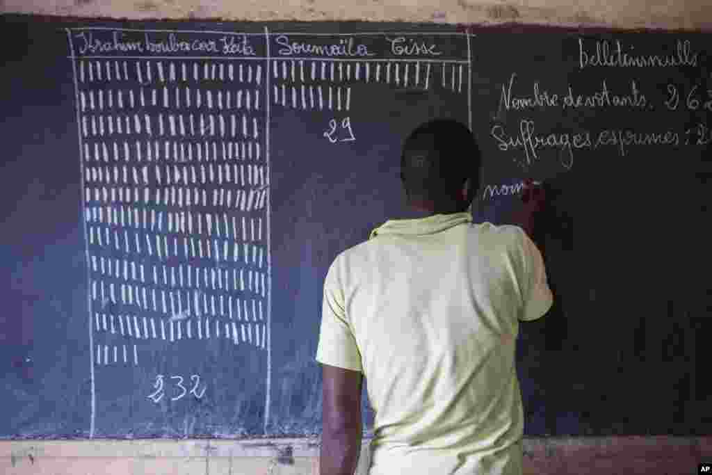 An election worker tallies votes after the close of polls in Mali's presidential runoff, Bamako, August 11, 2013.