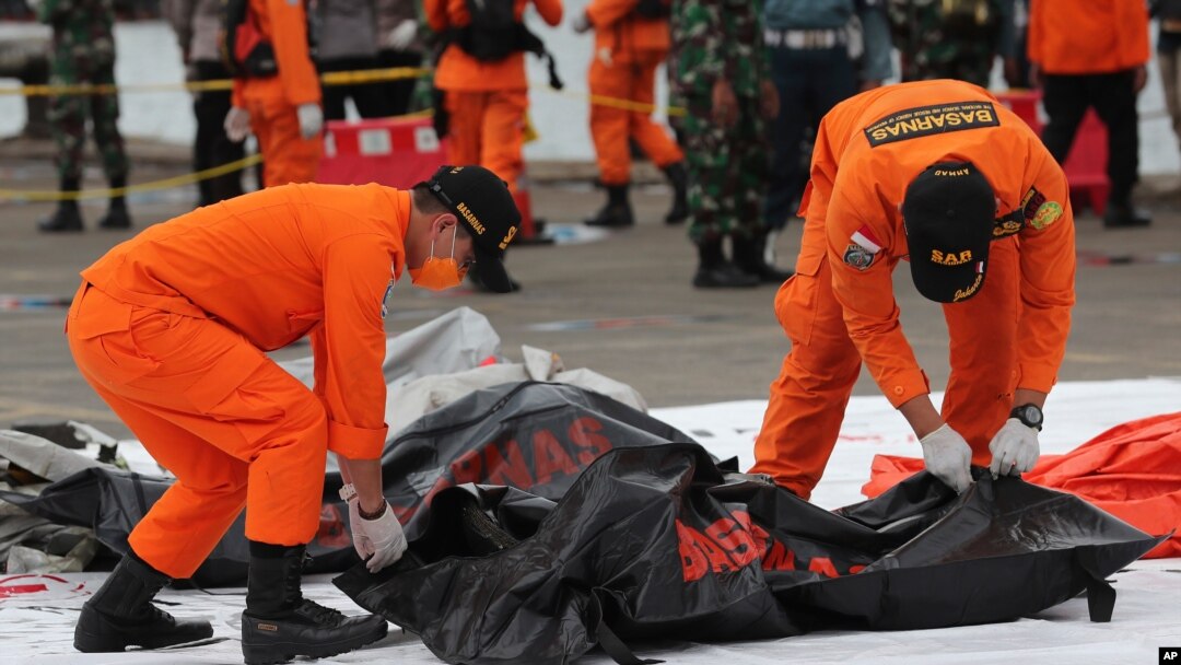 Spasioci nose vreću u kojoj su posmrtni ostaci ljudi izvučeni iz voda u koje je pao avion Srividžaja era, u Tanjung Prioku in Jakarta, Indonezija, 10. januara 2021.