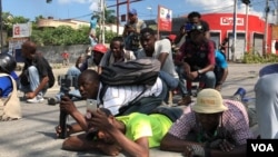 Para jurnalis Haiti bertiarap untuk menghindari terkena tembakan pada saat bentrokan antara polisi dan demonstran anti pemerintah di Port-au-Prince, Haiti, Kamis (31/10). 