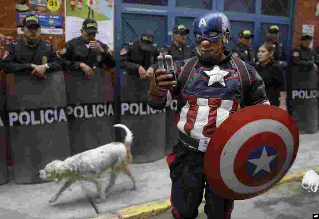 A clown dressed as comic book character Captain America chats with a friend as he takes part in a march celebrating Peruvian Clown Day in Lima, Peru.
