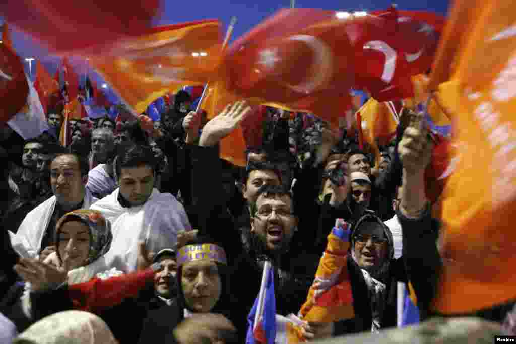 Pendukung Perdana Menteri Turki PM Tayyip Erdogan meneriakkan sloan-slogan saat berkumpul untuk menyambut kedatangan perdana menteri itu di Bandara Ataturk Istanbul. Pengadilan Turki memblokir upaya pemerintah untuk memaksa polisi mengungkapkan penyelidikan terhadap atasan mereka sebagai kemunduran bagi upaya Erdogan dalam mengelola dampak dari skandal korupsi tingkat tinggi.