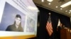 The image of Samuel Woodward is displayed as Orange County District Attorney Tony Rackauckas, right, speaks during a news conference, Aug. 2, 2018, in Santa Ana, Calif. Rackauckas said officials would file a hate crime sentencing enhancement against Woodward, 21, in the slaying of Blaze Bernstein, 19. 