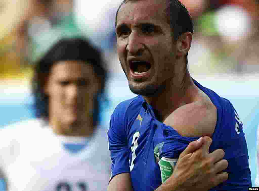 Pemain Italia Giorgio Chiellini menunjukkan bekas gigitan yang dilakukan pemain Uruguay Luis Suarez dalam pertandingan Piala Dunia di Natal, Brazil.