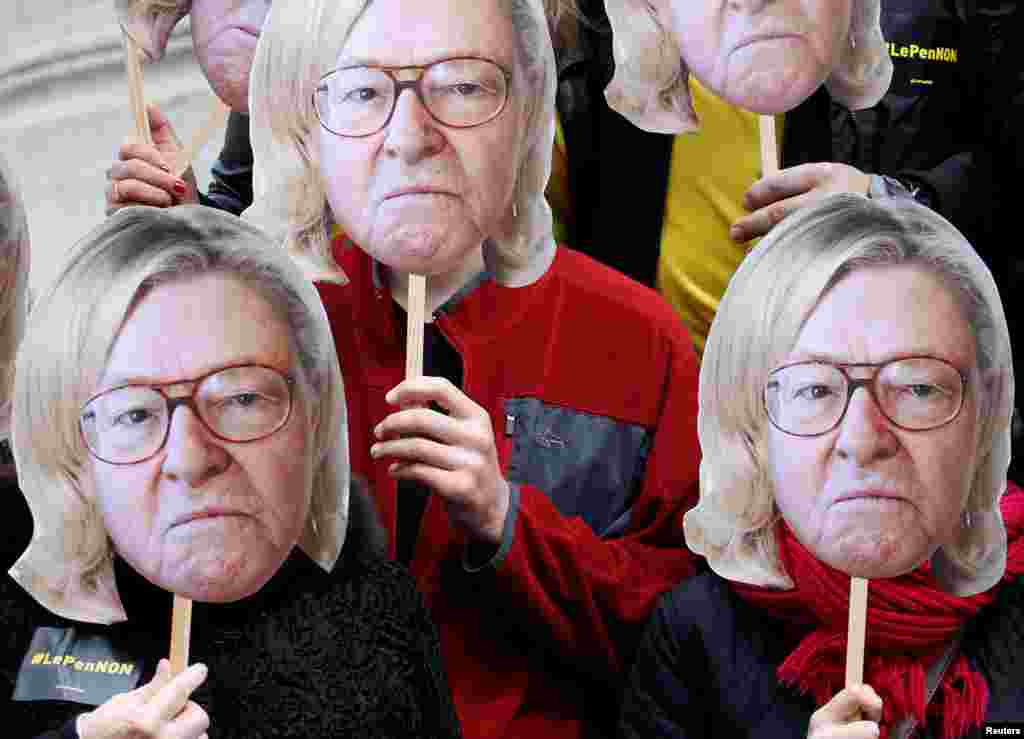 Aktivis mengenakan masker yang menggambarkan wajah Jean-Marie Le Pen, pendiri Front Nasional ekstrem kanan Perancis, dengan rambut putrinya Marine Le Pen, capres Front Nasional Perancis (FN) untuk pemilihan presiden 2017, dalam aksi unjuk rasa sebagai bagian dari pawai May Day tradisional di Paris, 1 Mei 2017.