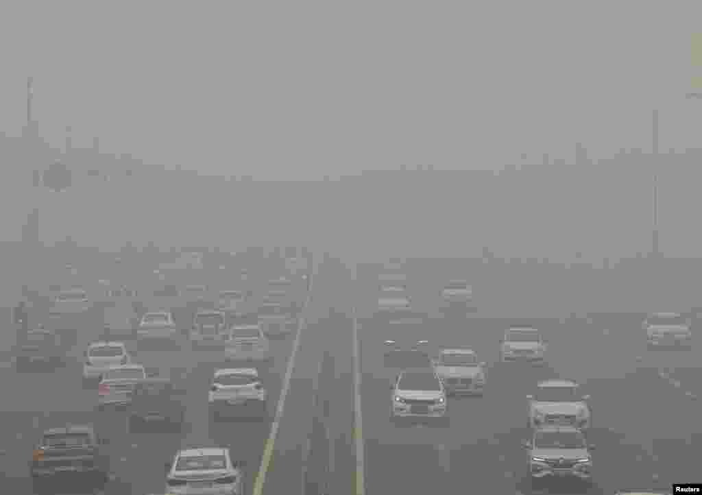 Traffic passes on a road as the sky is enveloped with smog after Delhi's air quality turned "severe" due to alarming air pollution, in New Delhi, India.