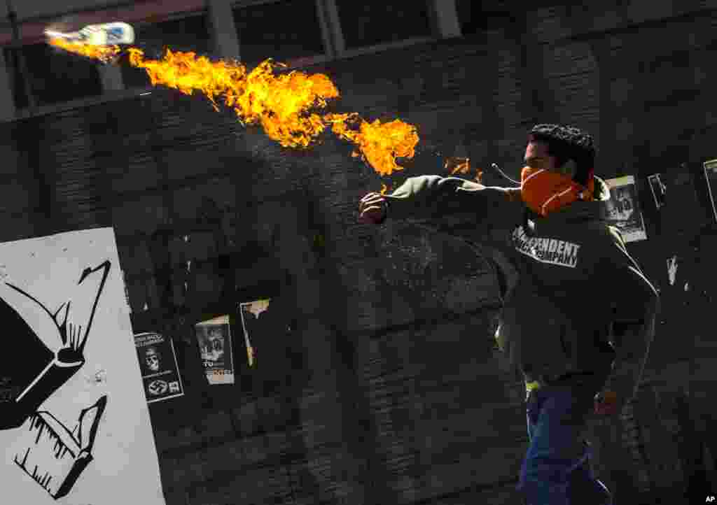 Seorang demonstran melemparkan bom molotov ke arah polisi dalam protes anti pemerintahan Presiden Nicolas Maduro di Caracas, Venezuela.