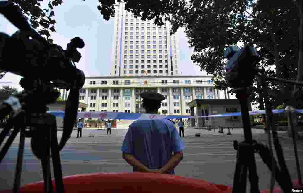 8月26日，一名警察守卫在济南中级法院的入口处。