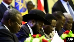 President of South Sudan, Salva Kiir signs a final power-sharing deal between South Sudanese arch-foes, Aug. 5, 2018, in Khartoum.