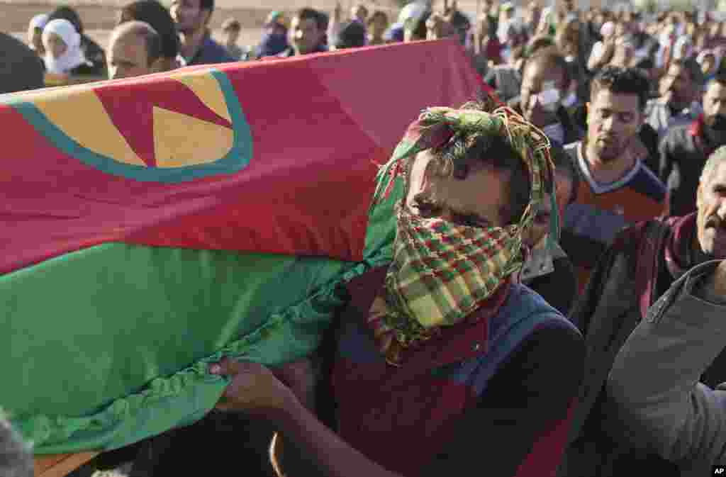 Des Kurdes portent le cercueil du combattant Ahmed Mustafa, qui est mort après avoir été blessé au combat contre les forces du groupe Etat islamique dans la ville syrienne de Koban, le 12 novembre 2014.