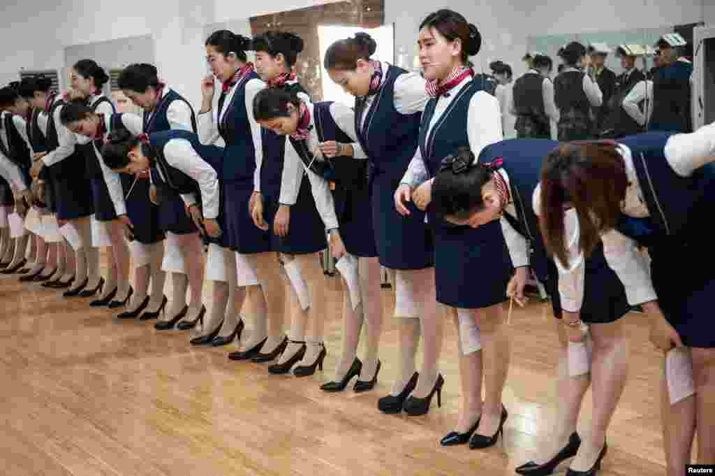 河北石家庄的空乘培训学校,想当空姐的学员们训练站立姿势和仪态,嘴里含着筷子以保持微笑,膝盖夹着纸张以保持并拢(2017年5月4日)