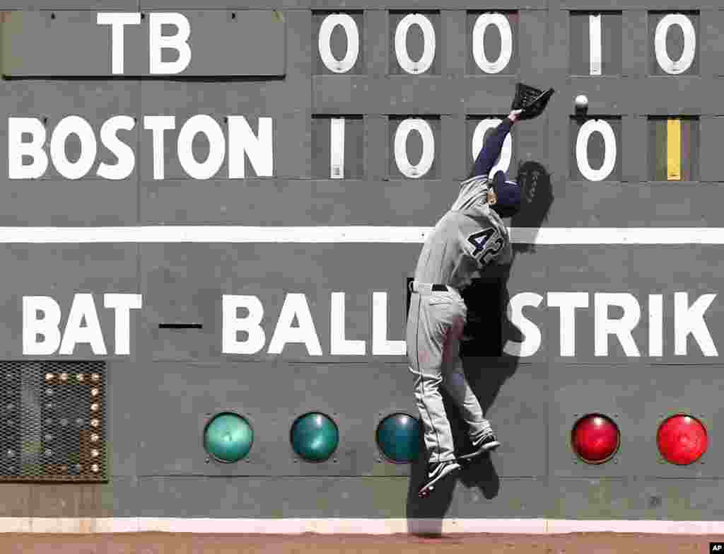 Pemain baseball klub &#39;Tampa Bay Rays&#39;, Matt Joyce gagal menangkap bola pukulan dari pemain &#39;Boston Red Sox&#39; Stephen Drew selama pertandingan di lapangan Fenway Park di Boston, Massachusetts.