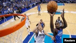 Dirk Nowitzki des Dallas Mavericks tente de bloquer Serge Ibaka d’ Oklahoma City Thunder (9) devant le panier, Texas, 7 mai 2011.