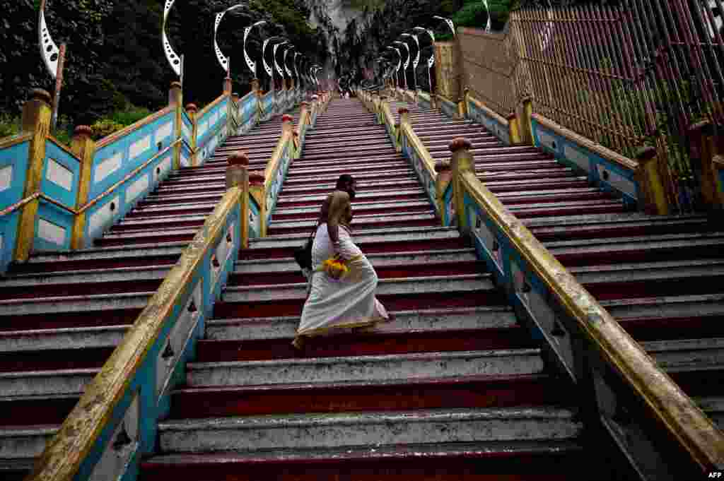 Seorang Pendeta Hindu berjalan menaiki tangga berjumlah 272 ke candi Batu Caves yang terletak di luar Kuala Lumpur, Malaysia. Kuil yang dibangun di dalam gua terbuat dari batu kapur yang telah berusia berabad-abad itu, adalah salah satu kuil Hindu yang paling populer diluar India, sebagai pemujaan kepada dewa Murugan. 