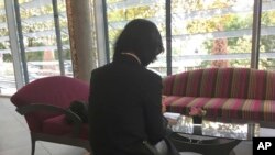 FILE - Grace Meng, the wife of former Interpol President Meng Hongwei, who does not want her face shown, is seen in the lobby of an hotel in Lyon, central France, Oct. 7, 2018.