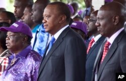 Kenyan President Uhuru Kenyatta, center, with Francis Atwoli, General Secretary of The Central Organization of Trade Unions (COTU) Kenya, left, and Kenyan Vice President William Ruto, right, watch the Labor Day Celebration Parade at Uhuru Park, Nairobi, Kenya, May 1, 2017.
