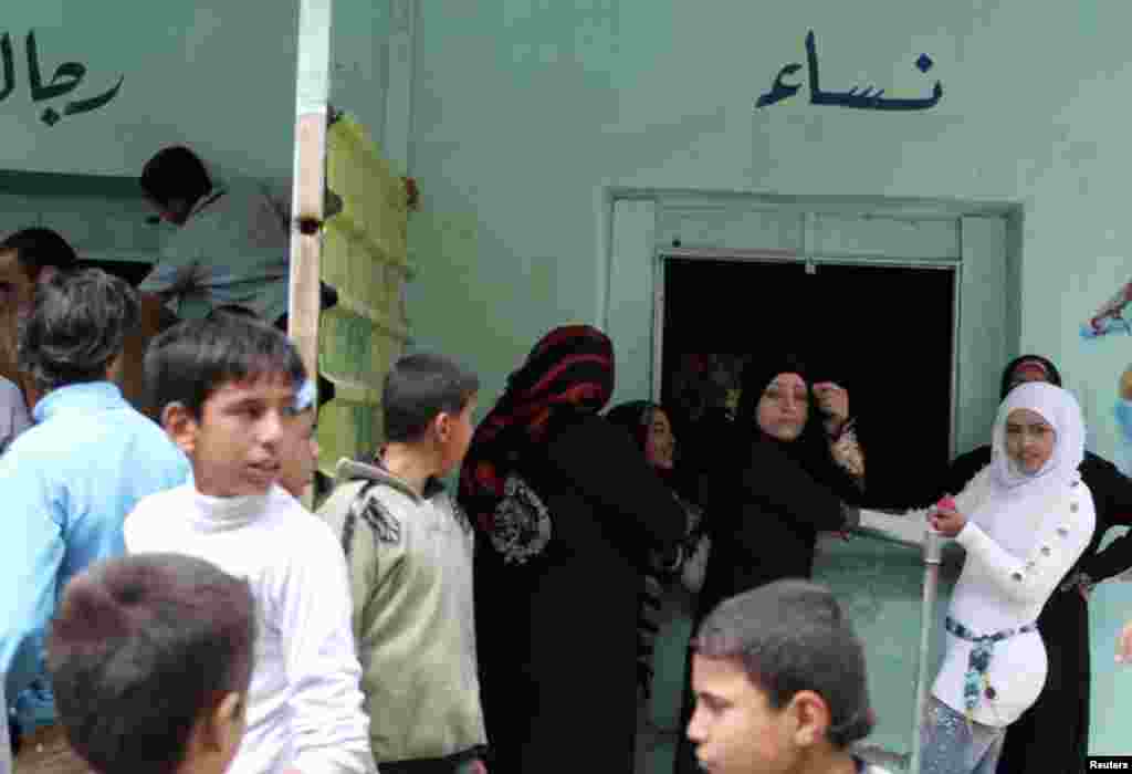 Residents gather outside a bakery to buy bread in al-Harak city, Deraa, Syria, March 27, 2013.