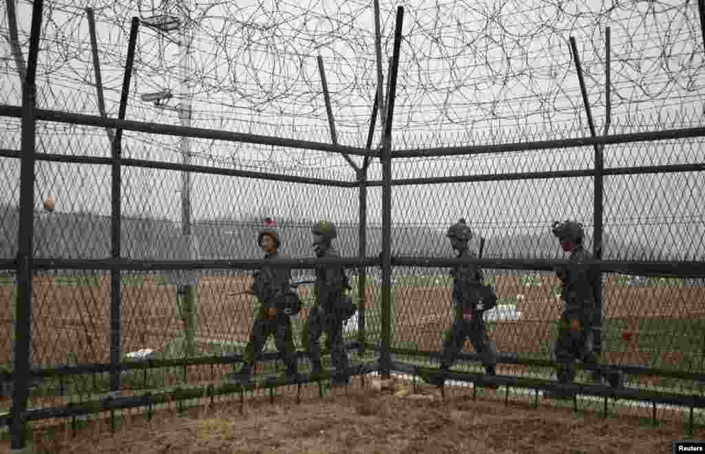 South Korean soldiers patrol along a barbed-wire fence, near the demilitarized zone that separates the two Koreas in Paju, north of Seoul, April 5, 2013.