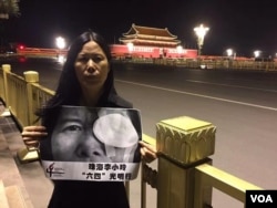 广东维权人士李小玲6月3日晚到北京天安门举牌 (参与网图片)