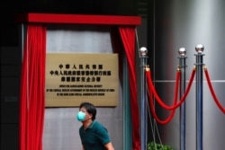 一名男子走过香港一家酒店外北京新设的驻港国安公署的牌子。（2020年7月8日）