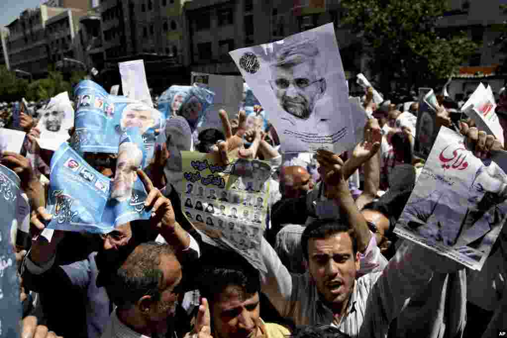 Supporters of presidential candidates Ali Akbar Velayati, shown in the poster at right, and Saeed Jalili, center on the poster, attend a street campaign after Friday prayers, Tehran, Iran, June 7, 2013.