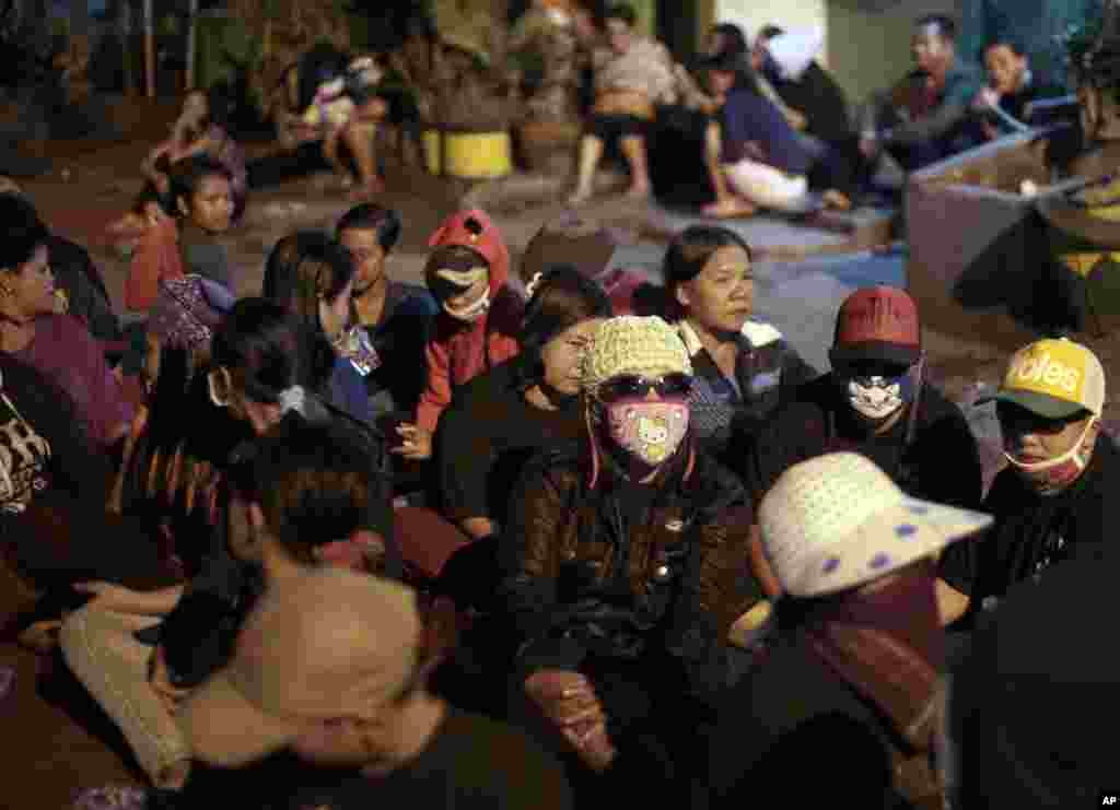 Para pekerja seks duduk di tengah jalan dalam sebuah protes melawan penutupan tempat lokalisasi Dolly di Surabaya (18/6). (AP/Dita Alangkara)