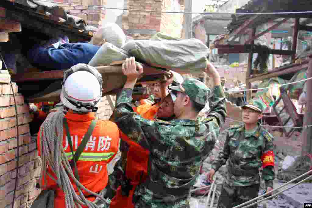 Regu penyelamat berusaha mengeluarkan seorang laki-laki lanjut usia yang lumpuh dari rumahnya yang rusak di kota Qingren di Kabupaten Lushan yang hancur akibat gempa berkekuatan 7.0 menngoncang kota Ya'an di Provinsi Sichuan, China barat daya