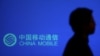 一名男子走过有中国移动标识的广告牌。