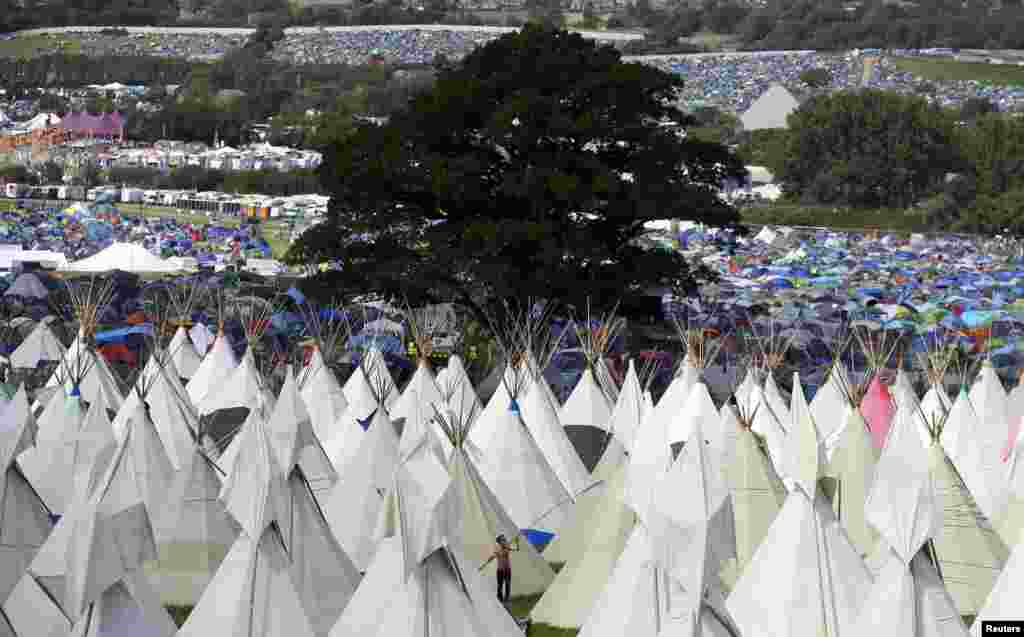 Warga Inggris yang menghadiri festival tadisional Glastonbury mendirikan tenda di di kota Somerset.