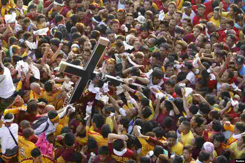 Ummat Katholik Filipina berebut 'Nazarene Hitam' berbentuk Patung Yesus, dalam upacara di kota Manila. 'Nazarene Hitam' dipercaya bisa menyembuhkan penyakit sebagaimana mu'jizat Yesus.