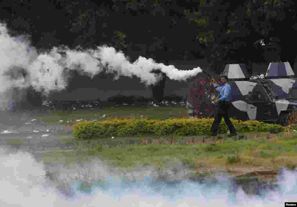 A policeman fires tear gas to disperse demonstrators during the Revolution March towards the prime minister's house in Islamabad, Sept. 1, 2014.