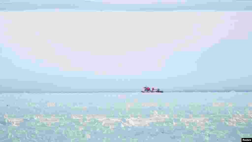Kapal pemecah es Xue Long (Naga Salju) yang berada di atas tumpukan es tidak dapat mencapai kapal Rusia yang terperangkap di Antartika Timur, MV Akademik Shokalskiy, sekitar 185 kilometer sebelah timur stasiun Antartika Perancis Dumont D'Urville.