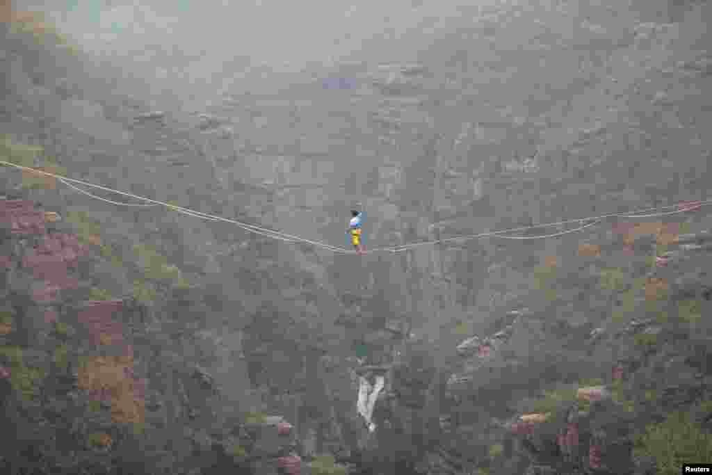 Pria Perancis, Theo Sanson, berjalan di atas kabel di antara pegunungan dalam lomba di Jiaozuo, Henan, China.