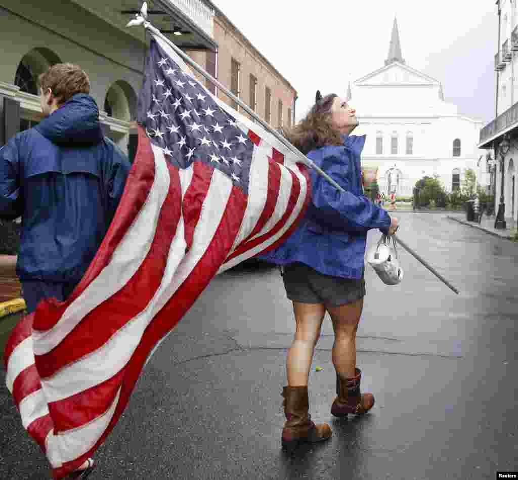 Shelly Ackel of New Orleans carries an American flag through the French Quarter as Hurricane Isaac approaches New Orleans, Louisiana August 28, 2012.