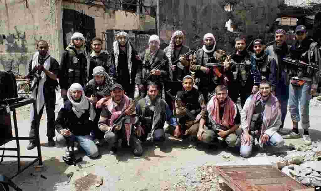 Para pejuang yang bergabung dalam Tentara Pembebasan Suriah berfoto bersama sebelum meninggalkan kota Homs, Suriah, 7 Mei 2014. (AP Photo/Komite Koordinasi Wilayah Khalidiya di Homs)