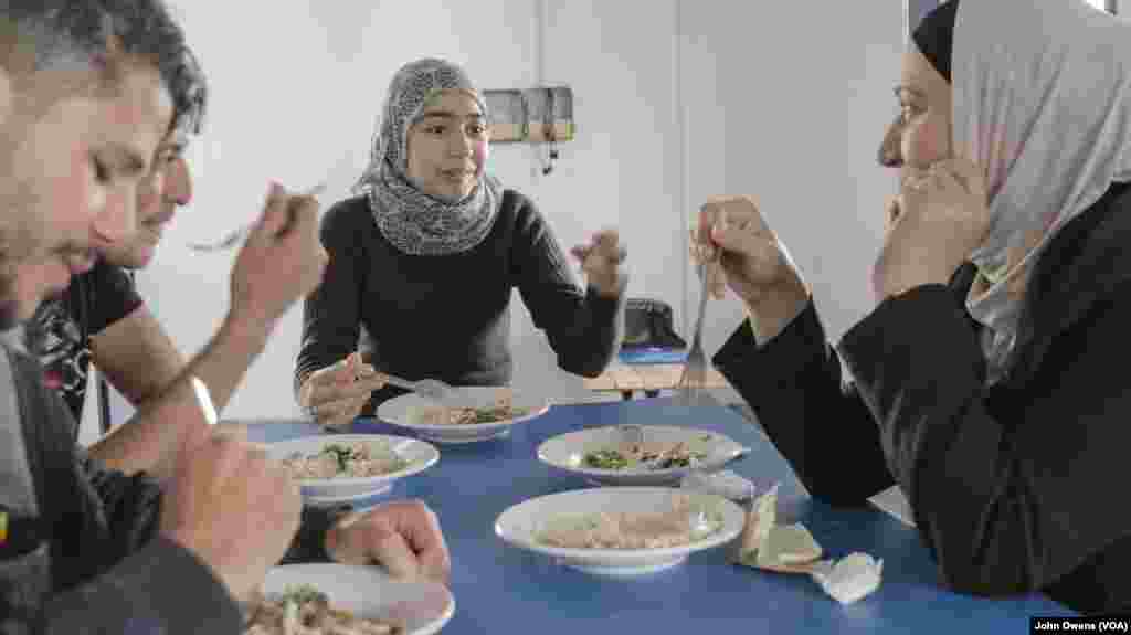 Sekelompok pengungsi menikmati makan siang di pusat komunitas Khora, di distrik Exarchia, Athena di Yunani (24/10).