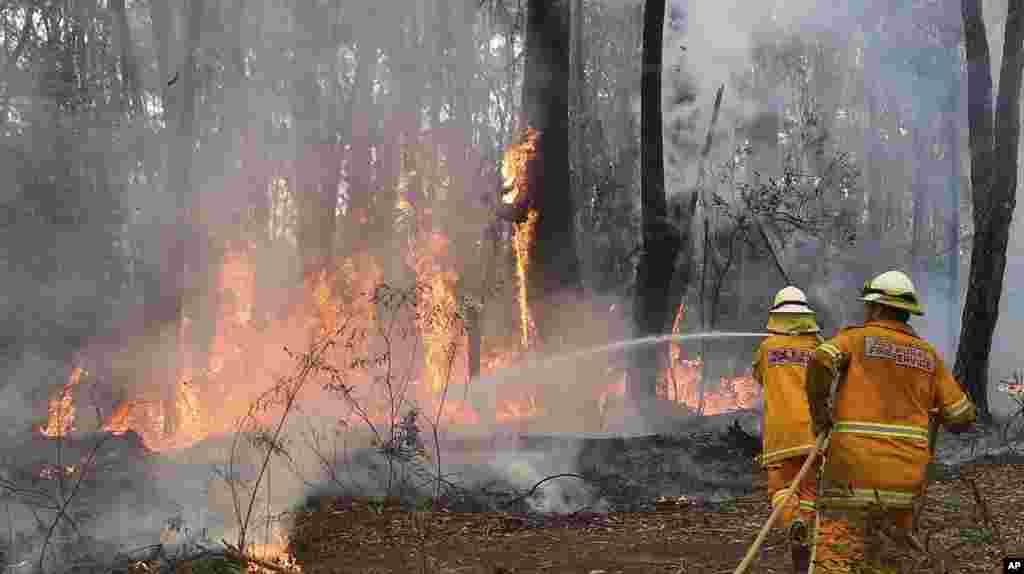 A firefighter tries to control flames near houses in Bilpin, west of Sydney, Oct. 22, 2013.