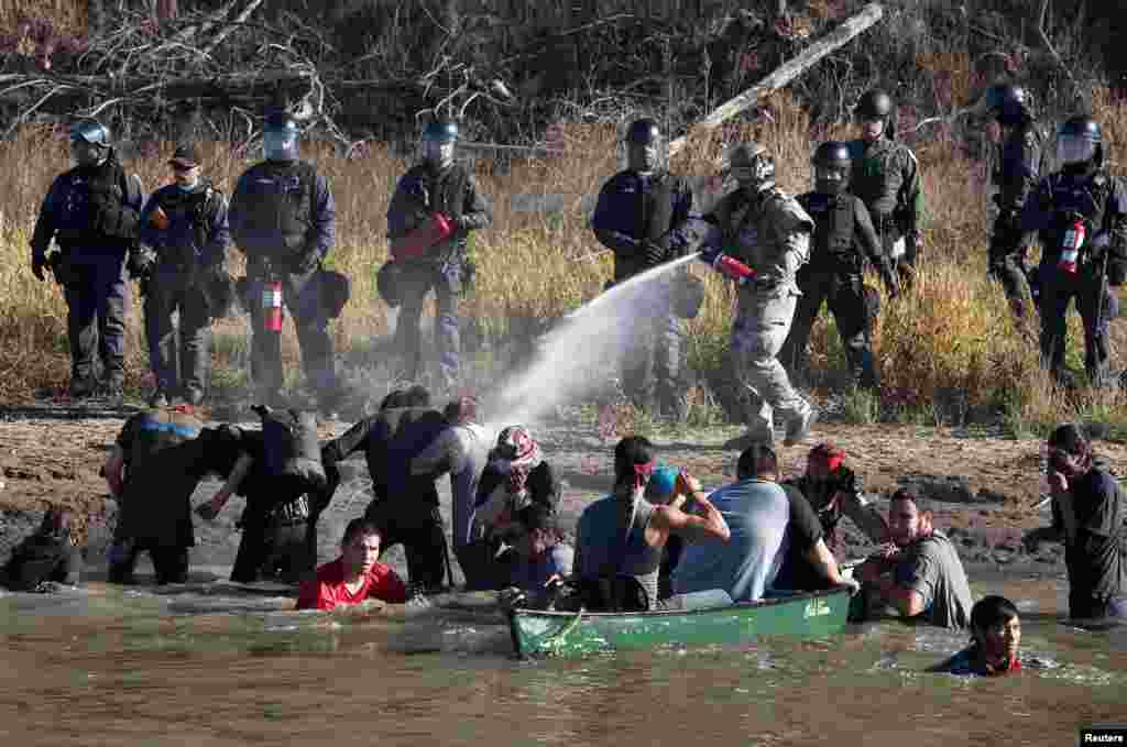 Polisi menggunakan semprotan cabe (pepper spray) ke arah para demonstran yang berusaha mendekati konstruksi pipa minyak di dekat tempat reservasi suku Indian 'Standing Rock' di Cannon Ball, North Dakota, AS.