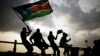 Southern Sudanese wave flags and cheer at the Republic of South Sudan's first national soccer match in the capital of Juba, July 10, 2011. 