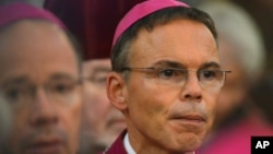 FILE - In this Sept. 24, 2013 file picture Franz-Peter Tebartz-van Elst, right, Bishop of Limburg, Germany, attends a mass during a meeting of German Bishops in Fulda, Germany.