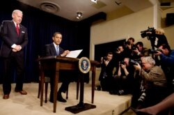 FILE - US Vice President Joseph Biden (L) watches as President Barack Obama signs an executive order on Executive Branch ethics as news photographers document at the Eisenhower Executive Office Building in the White House, Washington, Jan. 21, 2009.