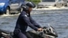 An Air Force officer rides his motorcycle through a flooded Paholyothin road near Don Muang airport in Bangkok, Thailand, October 25, 2011.