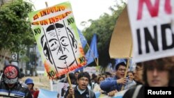 Para pengunjuk rasa menyerukan slogan yang menyuarakan penolakan atas permohonan pengampunan bagi mantan Presiden Alberto Fujimori di pusat ibukota Peru, Lima (22/11). 