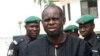 Bayelsa State Governor Diepreye Alamieyeseigha, centre, stands outside his house guarded by policemen in Yenagoa, Nigeria, in this file photo dated November 27, 2005.